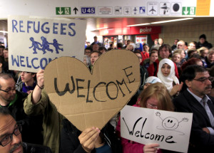 Wellwishers wave to migrants arriving at main railway station in Dortmund