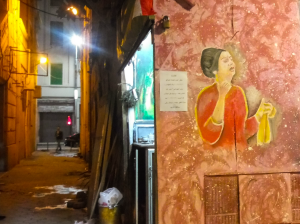 Alessandria, rappresentazione dell’iconica cantante egiziana Umm Kulthum sui muri di un vicolo di un caffè locale