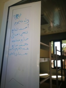 Scritte in arabo sulla porta di una camerata nel hotspot di Lampedusa (ph. Silvia De Meo)