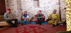 Un quartetto di musicisti suona Stambeli. Il maestro Salah el-Ouergli, penultimo da destra, suona il Gombri, alle estremità gli strumenti sono i Chkacheks